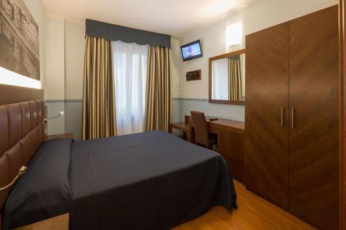 a bedroom with a bed and a desk and a cabinet at Hotel Terminus & Plaza in Pisa