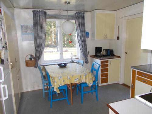 een keuken met een tafel en stoelen en een raam bij Furulund in Linneryd