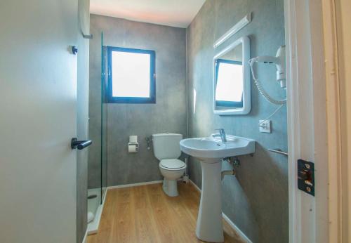 ein Badezimmer mit einem Waschbecken, einem WC und einem Spiegel in der Unterkunft SOL Y MAR in Cala en Blanes