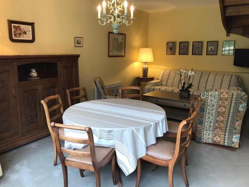 a dining room with a table and chairs and a bed at Les Terrasses de La Moglais in Lamballe