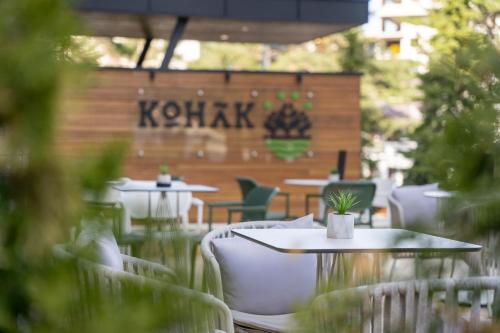 um restaurante com mesas e cadeiras e um cartaz que lê kritis em Konak Apartmani & SPA em Zlatibor