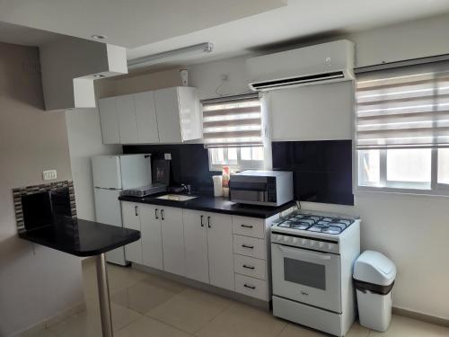 cocina con armarios blancos y fogones en Perfect House, en Eilat