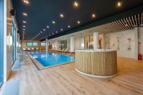 a large pool with a bar in the middle of a building at Konak Apartmani & SPA in Zlatibor