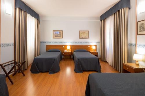 a hospital room with two beds in it at Hotel Terminus & Plaza in Pisa