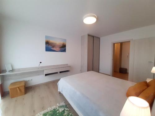 1 dormitorio blanco con 1 cama grande y 1 sofá en Apartamenty Aleksandry _ Flotylla en Świnoujście