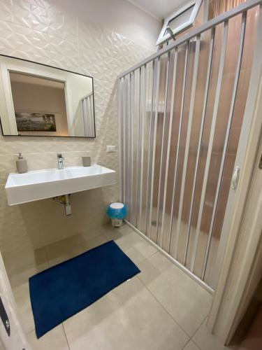 bagno con doccia, lavandino e specchio di Fondaco House a Napoli