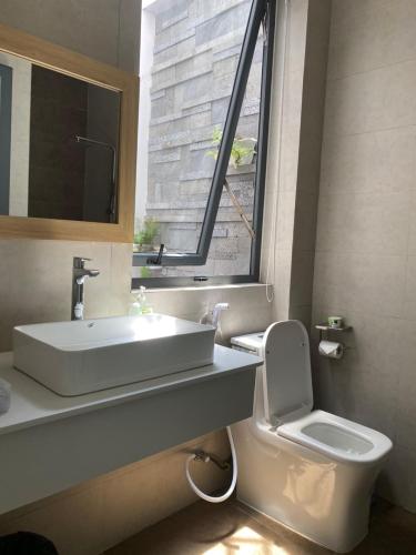 a bathroom with a sink and a toilet and a window at VISION HOTEL in Phan Rang