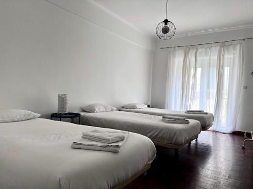 una camera con tre letti e una finestra di Flores Terrace Apartment a Lisbona