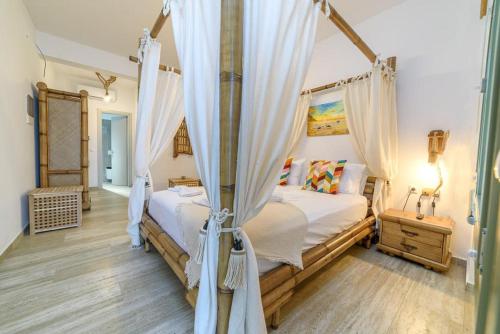 a bedroom with a canopy bed with curtains at CASA DOBRESCU KATIGIORGIS PELION in Argalasti