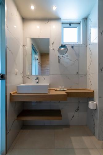 a bathroom with a sink and a mirror at Sunny Days in Tigaki