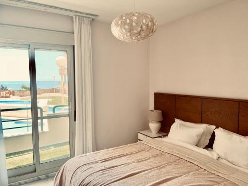 Un dormitorio con una cama y vistas a una piscina. en Apartment Sea Breeze – Apartamento Brisas del Mar, en Benalmádena