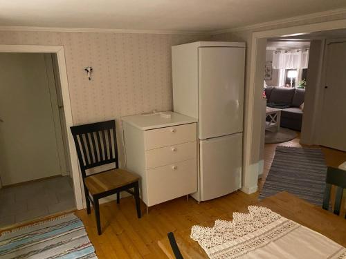 a kitchen with a white refrigerator and a chair at Idyll SKREA STRAND in Falkenberg