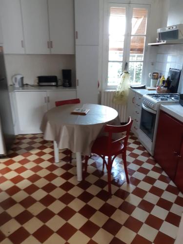 uma cozinha com uma mesa e cadeiras numa cozinha em Maison à Troyes em Troyes