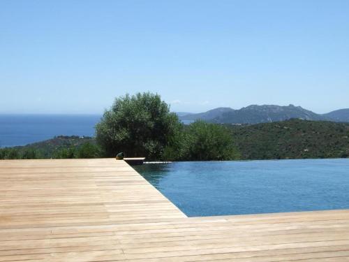 a swimming pool with a wooden deck and water at Chambres d'Hôtes Bianca Casa in Porto-Vecchio