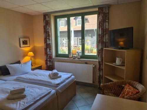 a hotel room with two beds and a window at "Spreehof" Apartmenthaus in Lehde in Lübbenau