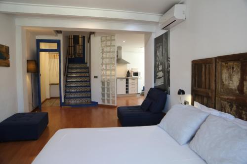 a bedroom with a bed and a living room at Las Coles Apartasuites in Xàtiva