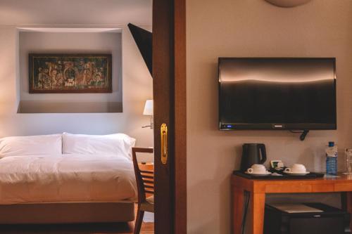 a hotel room with a bed and a flat screen tv at Abba Xalet Suites Hotel in Sispony