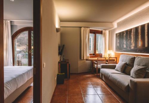 uma sala de estar com uma cama e um sofá em Abba Xalet Suites Hotel em Sispony