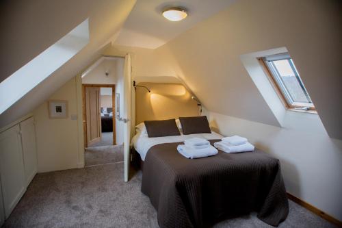 a bedroom with a bed with two towels on it at Crofts Mill in Ballater