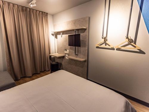 a room with a bed and two lights at ibis Budget Millau Viaduc in Millau