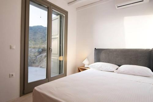 a bedroom with a large bed and a window at Dreamy Cycladic Luxury Summer House 2 in Serifos Chora