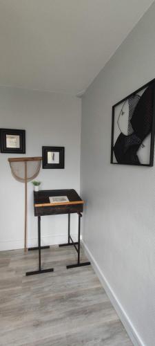 une chambre avec une table et des photos sur un mur dans l'établissement Victoria's Place, à Veules-les-Roses