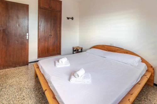 a bedroom with a wooden bed with two towels on it at Grifeu 6 Apartamento luminoso con terraza y vistas in Girona