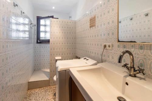 La salle de bains blanche est pourvue d'un lavabo et d'un miroir. dans l'établissement Grifeu 6 Apartamento luminoso con terraza y vistas, à Gérone