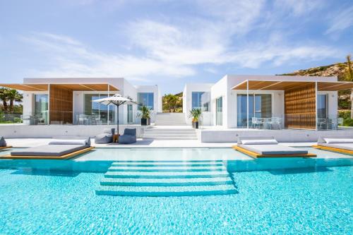 a villa with a swimming pool in front of a house at ISTIA LUXURY VILLAS in Karpathos Town