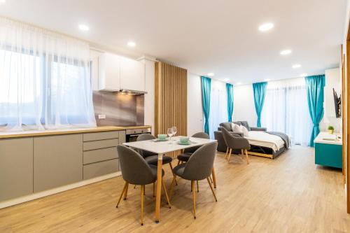 a kitchen and a living room with a table and chairs at Arena Residence in Cluj-Napoca