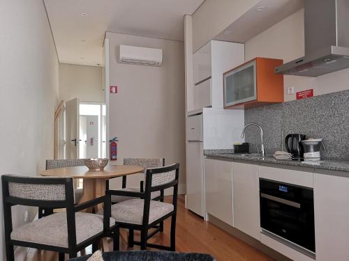uma cozinha com mesa e cadeiras num quarto em Mouzinho 129 - Carvalho no Porto