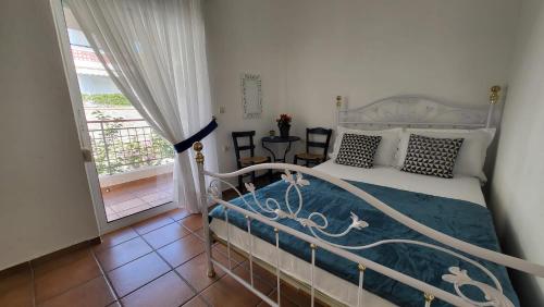 a bedroom with a white bed and a balcony at Mina House Siviri in Siviri