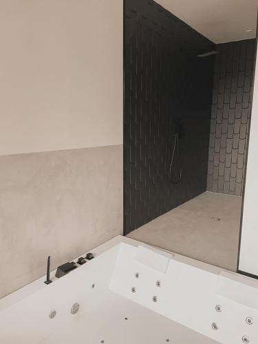a bathroom with a shower with a black wall at Atmos Hotel Boutique in Outes