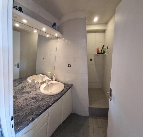 uma casa de banho com 2 lavatórios e um espelho grande em Marina 2 , appartement vue mer exceptionnelle em Saint-Cyprien