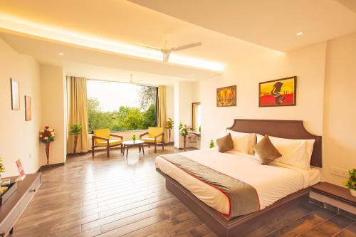ein Hotelzimmer mit einem Bett, einem Tisch und Stühlen in der Unterkunft Octave Parkland Suites in Nagpur