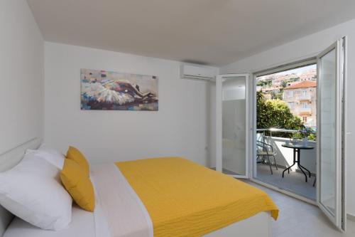 um quarto branco com uma cama e uma varanda em Apartments Fortinia Dubrovnik- FREE PARKING em Dubrovnik