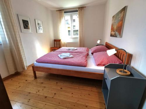 Schlafzimmer mit einem Bett mit roter Bettwäsche und einem Fenster in der Unterkunft Ferienlodge von Scotti in Neumagen-Dhron