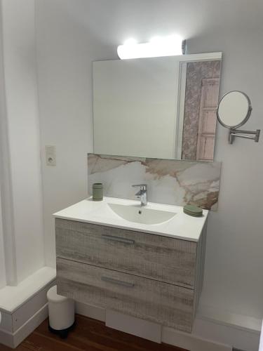 une salle de bain avec un lavabo et un miroir dans l'établissement Appartement avec balcon vue mer, tout équipé, à Mers-les-Bains