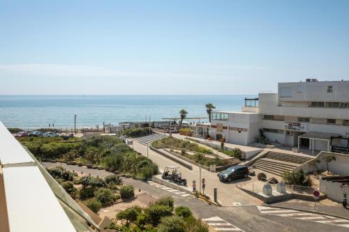 een uitzicht op een parkeerplaats naast de oceaan bij Village Naturiste - Emotion X Heliopolis sea view in Cap d'Agde