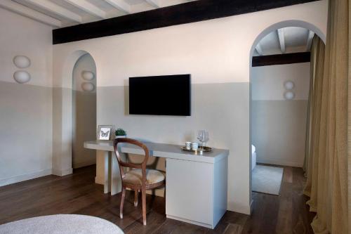 a room with a desk and a tv on a wall at Cà del Re in Verduno