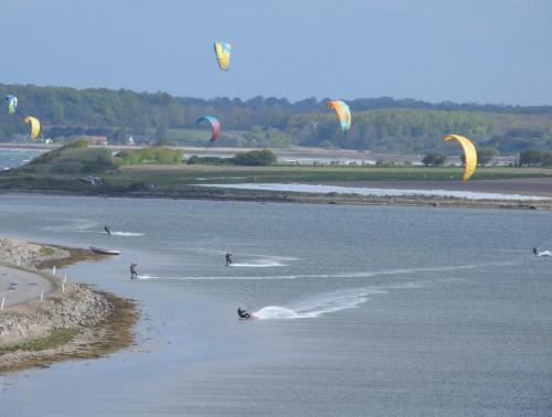a group of people kite surfing in the water at Aa Strand Camping in Ebberup