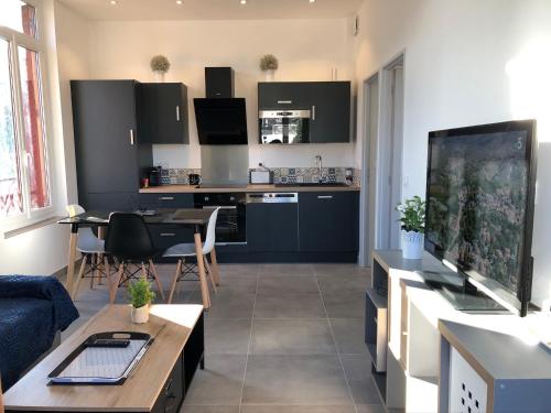 un salon avec une table et une cuisine dans l'établissement La Maison d’Alice, à Aix-les-Bains