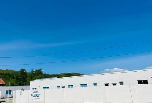 a white building with a blue sky in the background at Blue Sky Transalpina in Săsciori