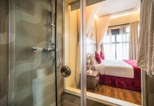 uma casa de banho com um chuveiro e um quarto com uma cama em Verona Hotel and Conference Center em Ruiru