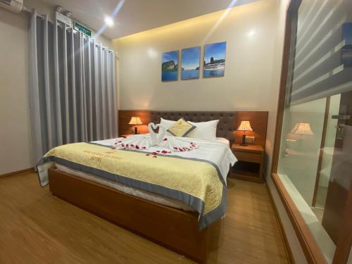 ein Schlafzimmer mit einem Bett, zwei Lampen und einem Fenster in der Unterkunft Khách sạn Đỉnh Hương Hạ Long in Hạ Long