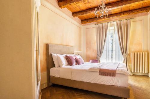 a bedroom with a bed with a chandelier and a window at VILLA CHIOVENDA Residenza d'Epoca in Premosello Chiovenda