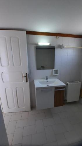 a bathroom with a sink and a white door at MOSXONAS House in Áyioi Asómatoi