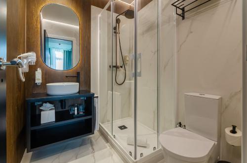 y baño con ducha, aseo y lavamanos. en Nicola Rossio Hotel en Lisboa