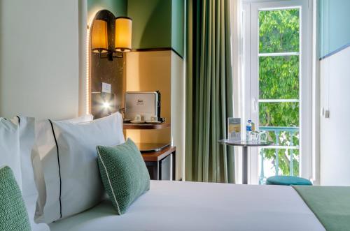 a bedroom with a white bed with a window at Nicola Rossio Hotel in Lisbon