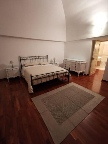 a bedroom with a bed and a rug on a wooden floor at Dimora Marila in Noci